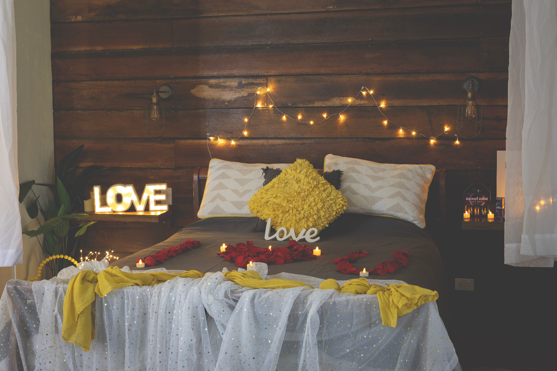 Rustic suite styled with fairy lights, rose petals and LOVE marquee